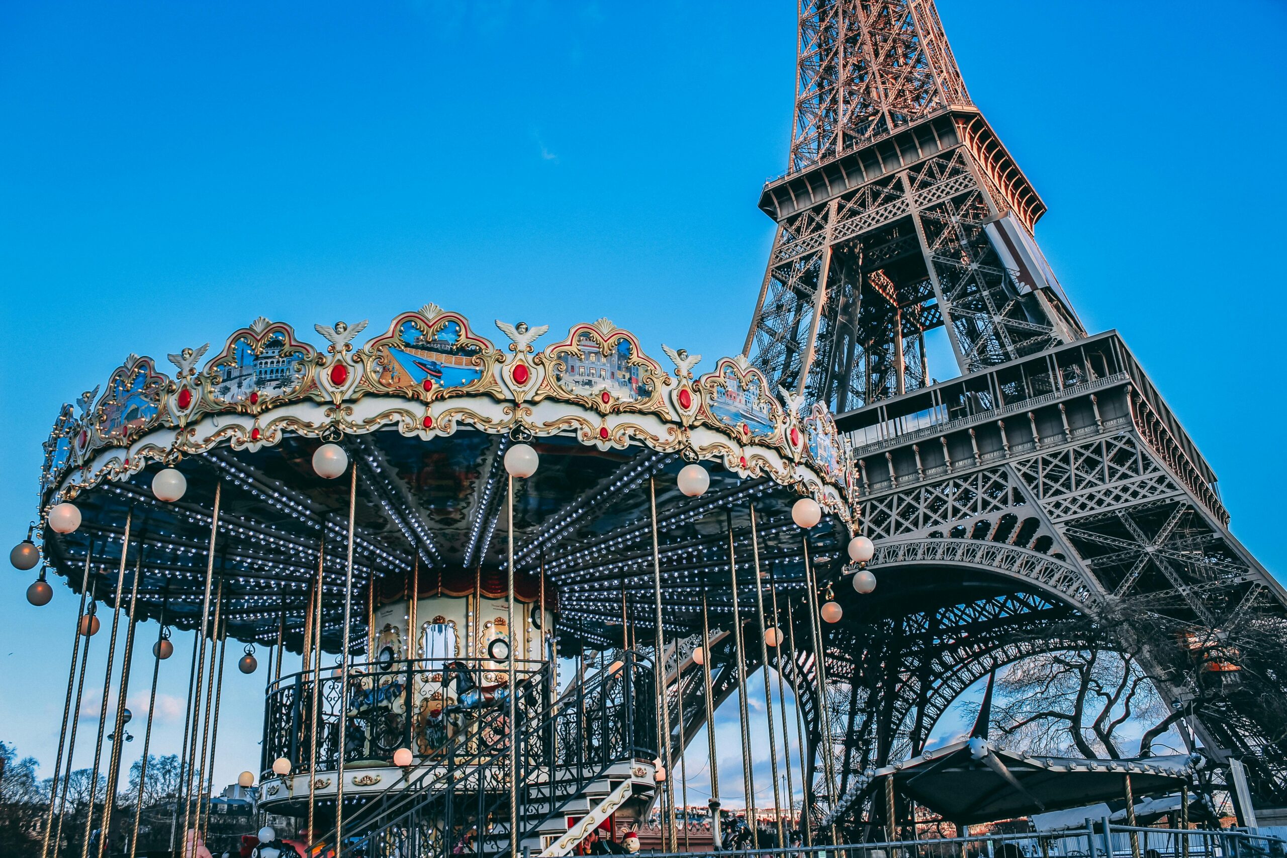 Eiffel Tower seen behind a vintage Parisian carousel with colorful details.