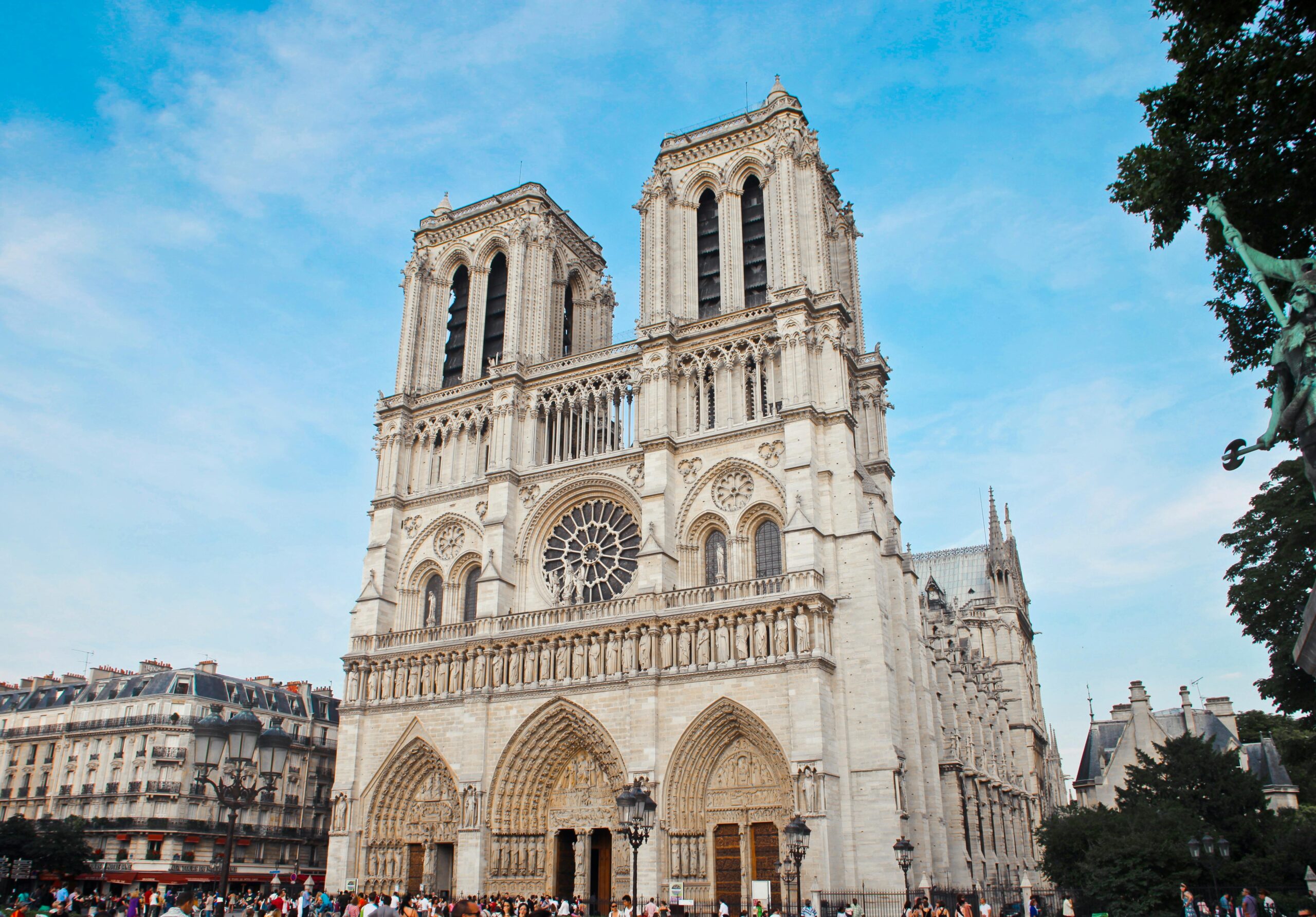 The iconic façade of Notre-Dame Cathedral in Paris, framed by blue skies.